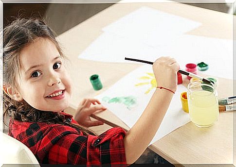 Girl painting a drawing with watercolors