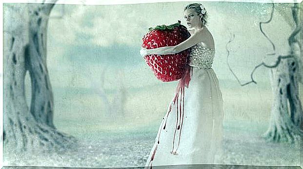 woman holding a strawberry