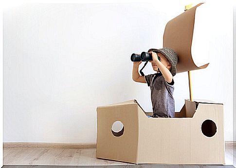 Boy playing in cardboard boat