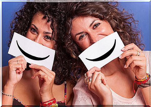 Female friends holding a sign with a smile