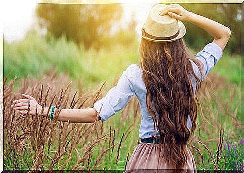 Woman with hat walking on footpath