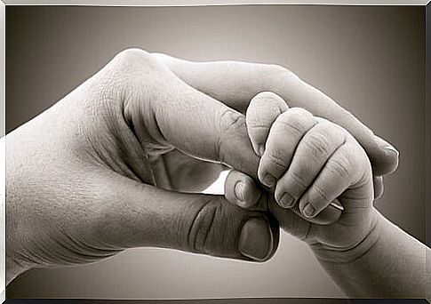 Hand of a baby holding his mother's to represent the bond of attachment