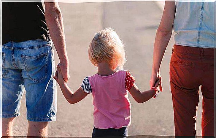 Parents holding hands by their child