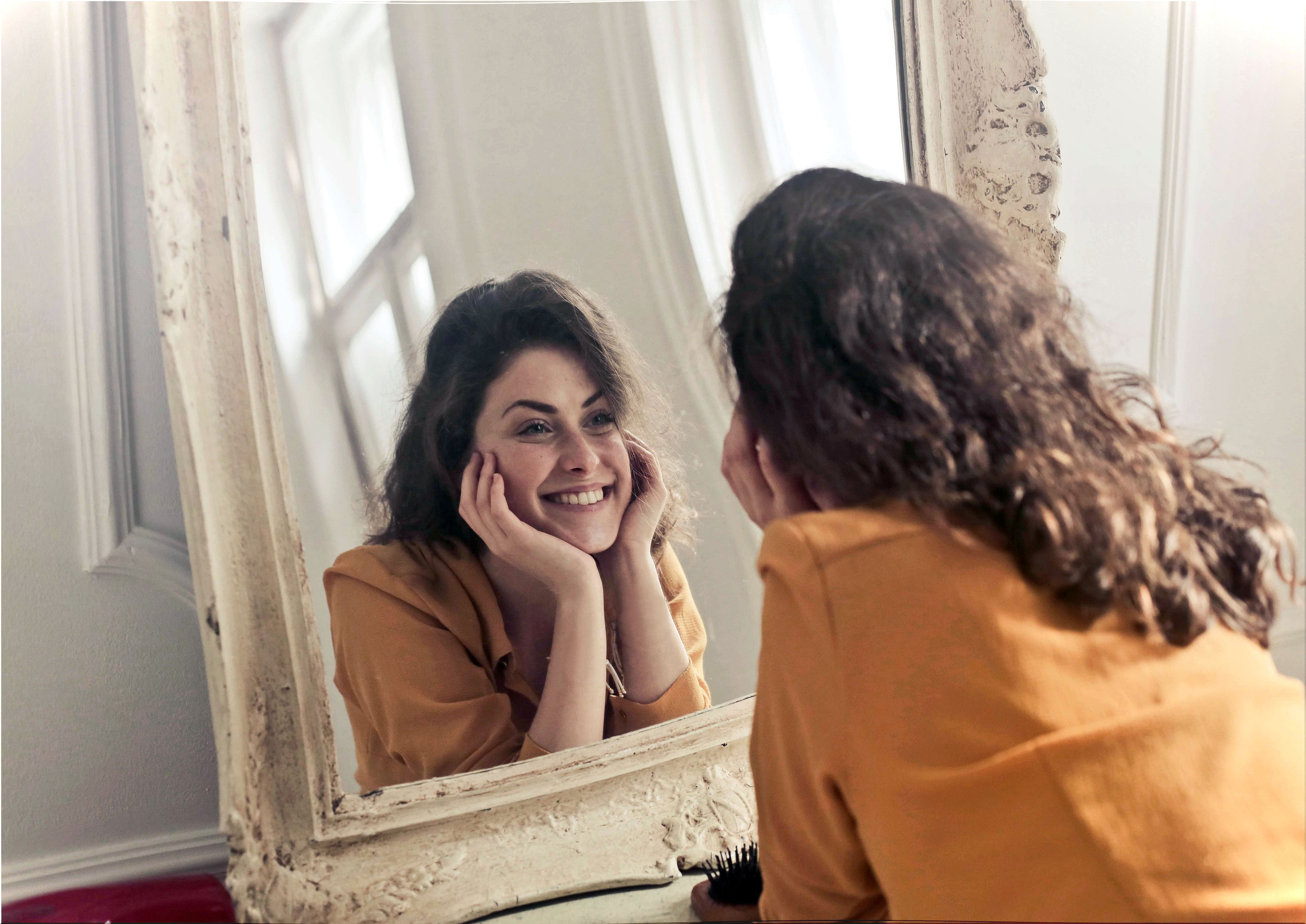 Woman with good self-esteem looking in the mirror