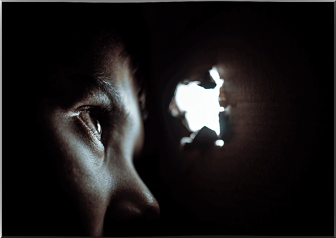 Boy looking through a hole