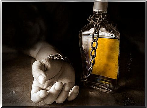 Hand chained to a bottle of alcohol