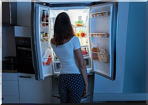 Woman with nocturnal eating syndrome in front of the refrigerator